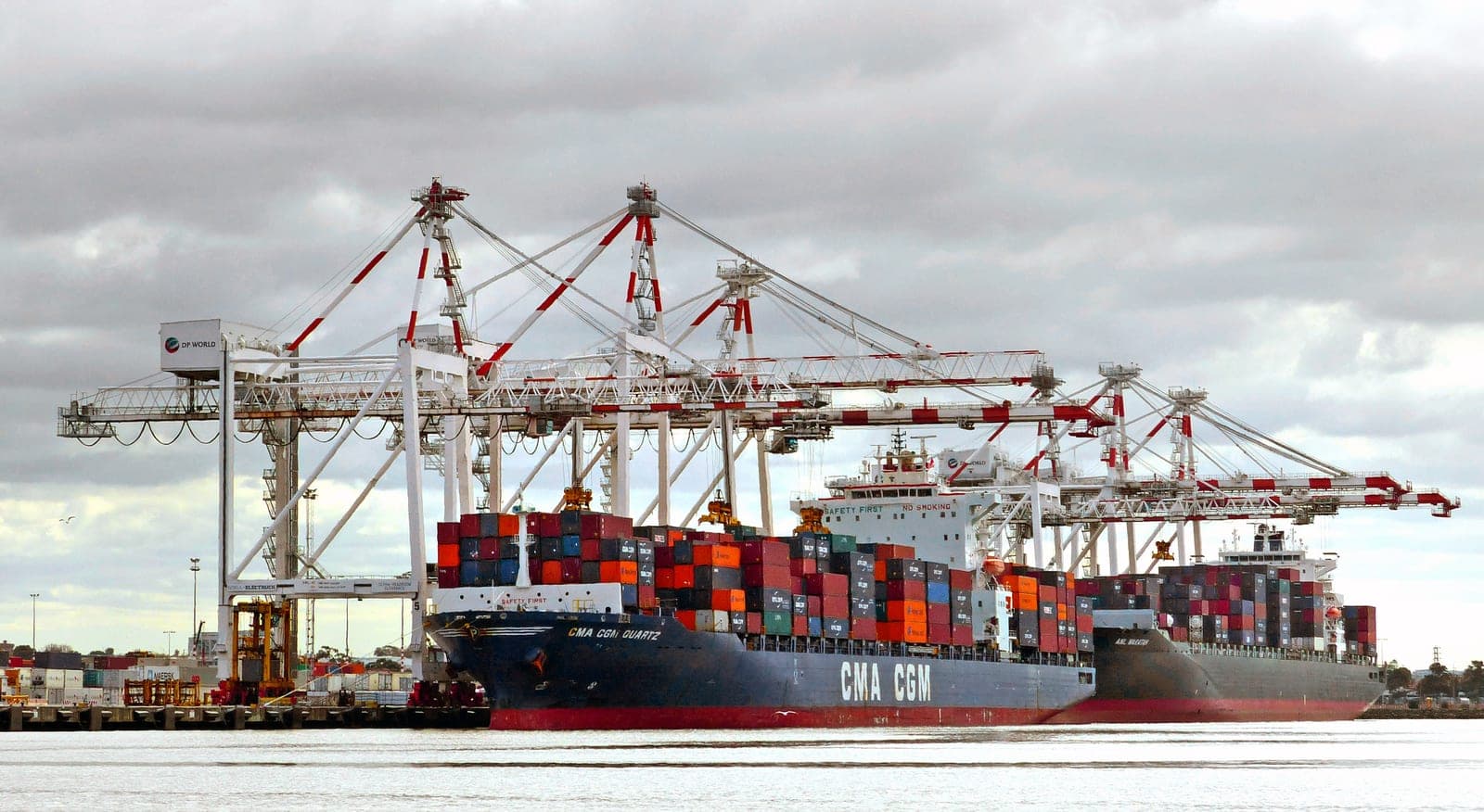Container ships being loaded at a port terminal, illustrating the shipping delays that make single-country sourcing risky